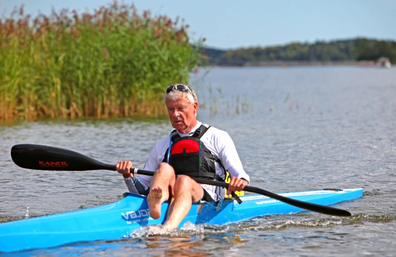 an old man kayaking in the water with oars