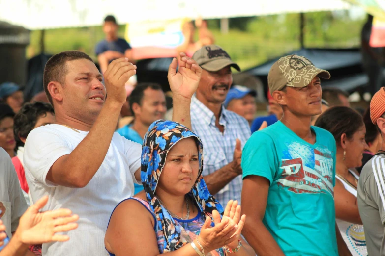 a group of people are sitting and clapping