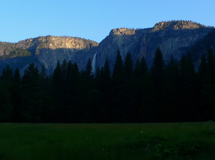 a green pasture with mountains in the background