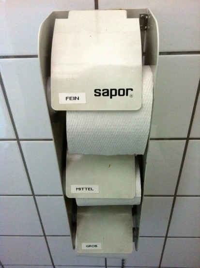 a toilet paper dispenser in a public restroom