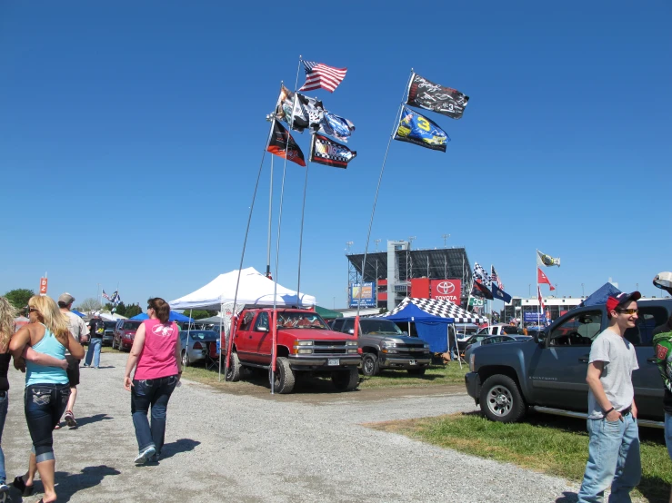 people walking around a car show area