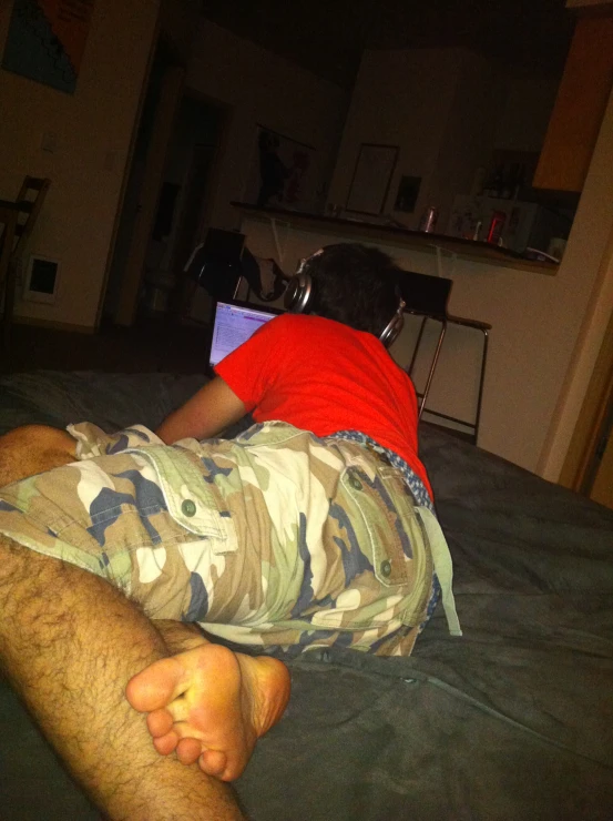 the man lays on his bed using the laptop