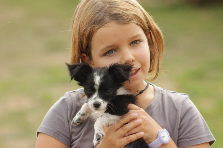 girl holding a small dog with a funny face