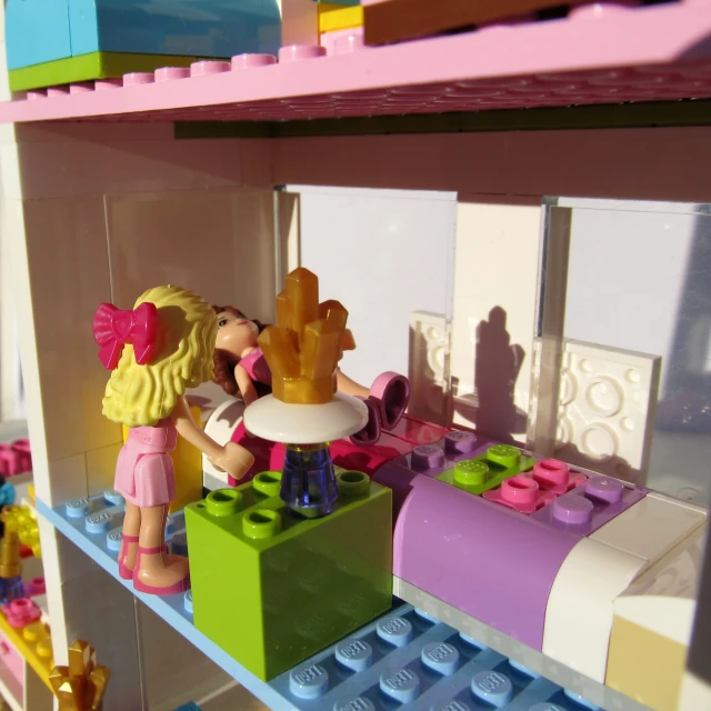 there are lego girls playing on a shelf