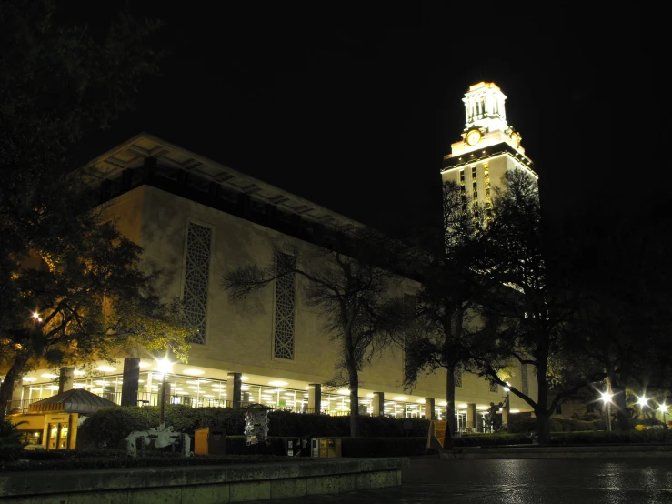 an illuminated clock tower at night, in the middle of the city