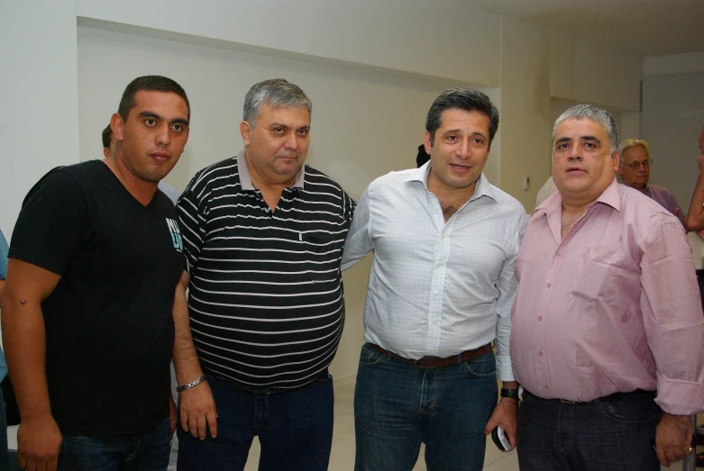 four men standing together in a room