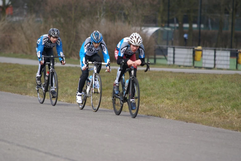 three professional cyclists race down a curved track