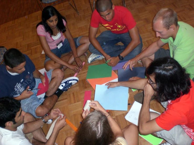 people sitting on the floor in a circle writing and drawing