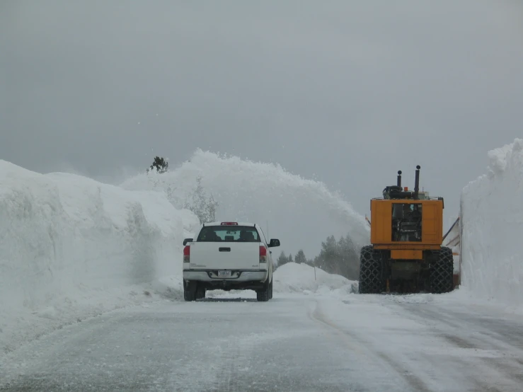 a truck driving in front of a large plow