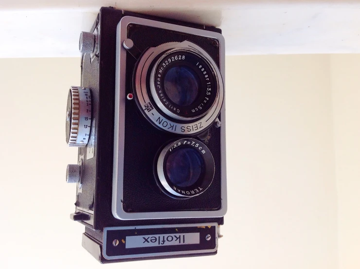 an old black camera sits atop a table