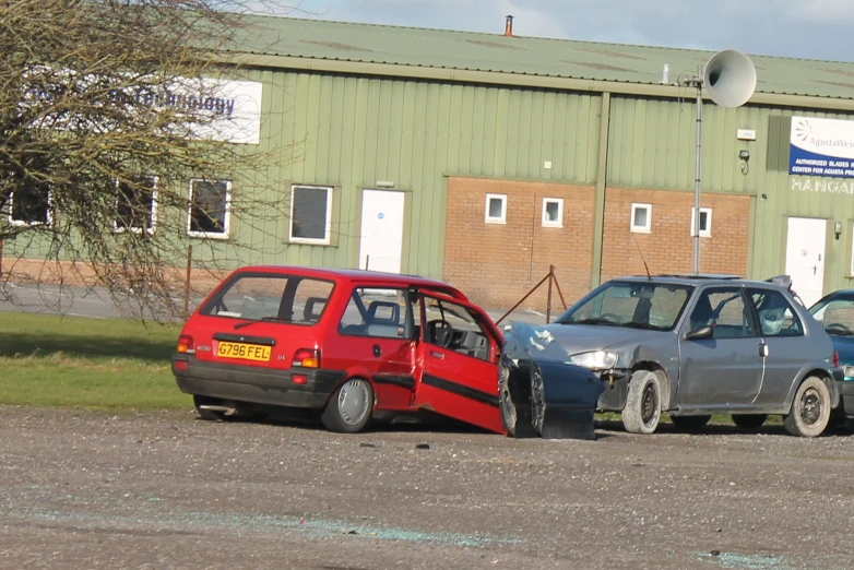 a small red car sits next to another smaller car