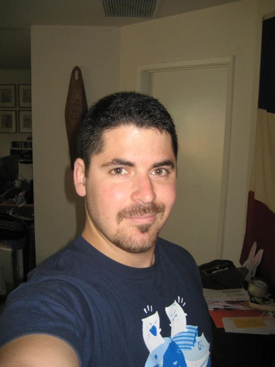 a man posing for a po while wearing a blue tshirt