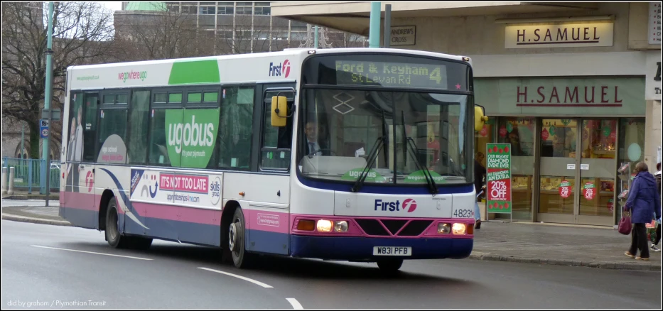 a bus driving down the street in front of a store