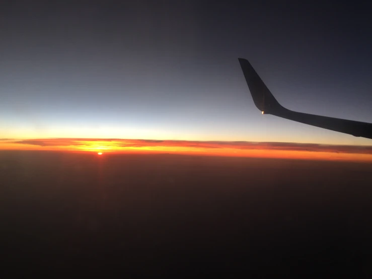 the sunset viewed from the plane window as it flies