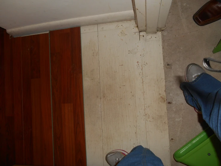 a room with a wooden floor and two feet and a wall