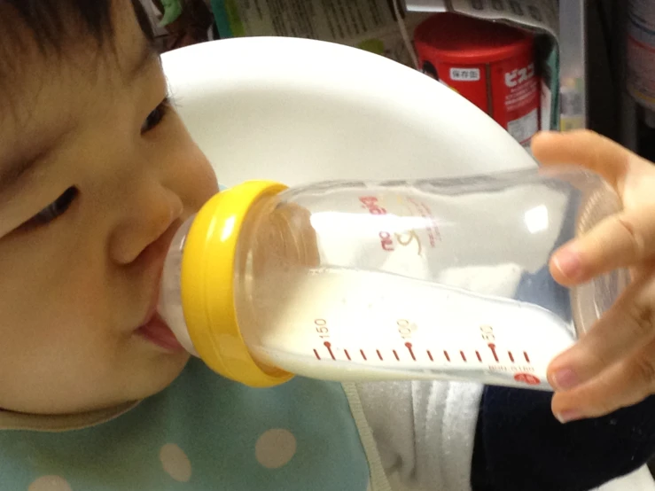 a baby boy drinking out of a bottle