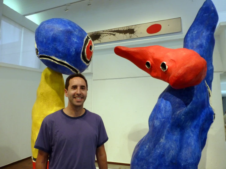 a man with two blue and red birds on his heads