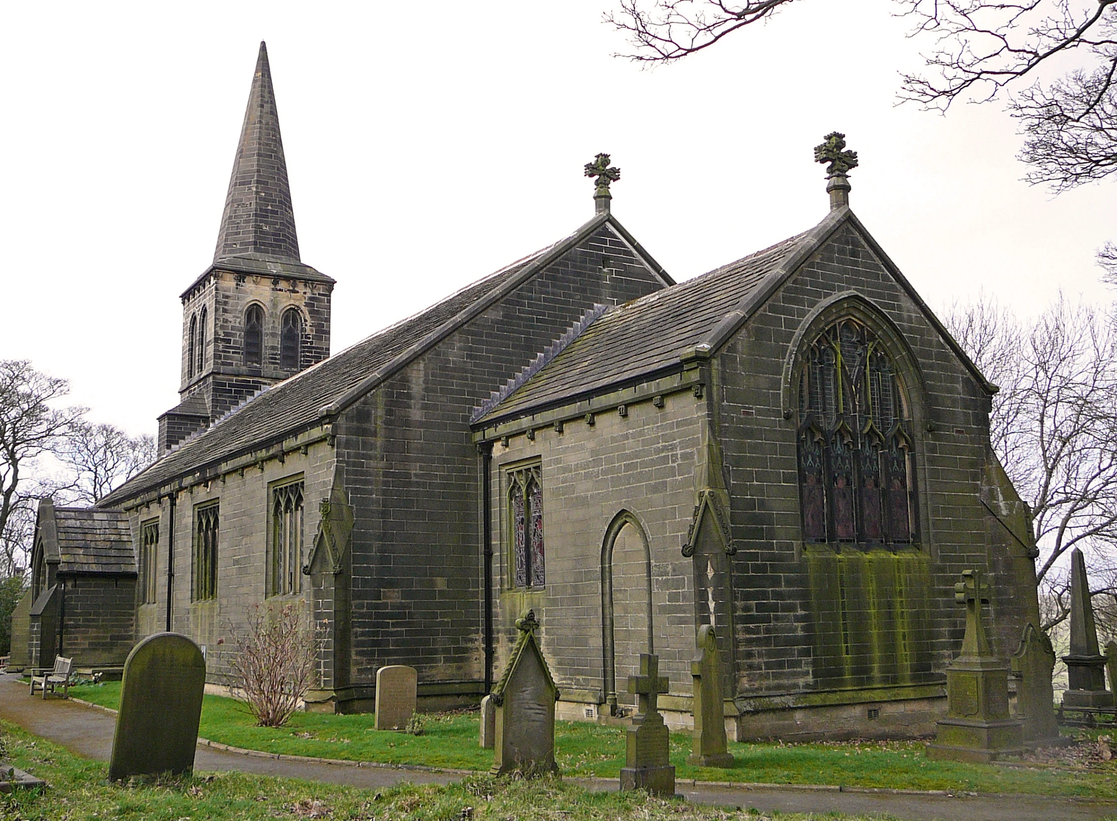 an old stone church with a steeple and graveyard