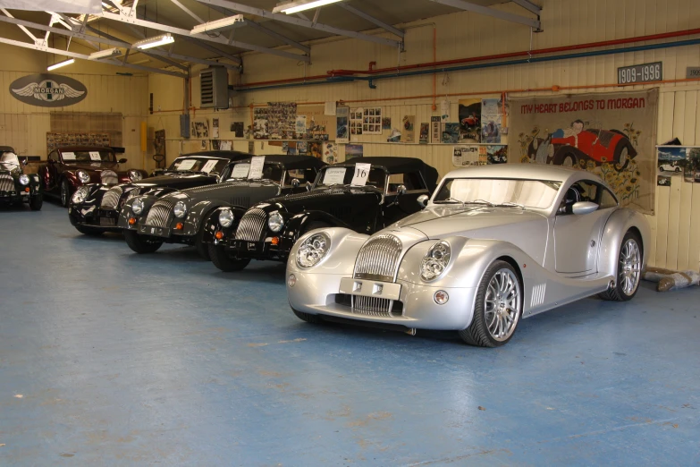 vintage cars lined up in a garage, waiting to be auction