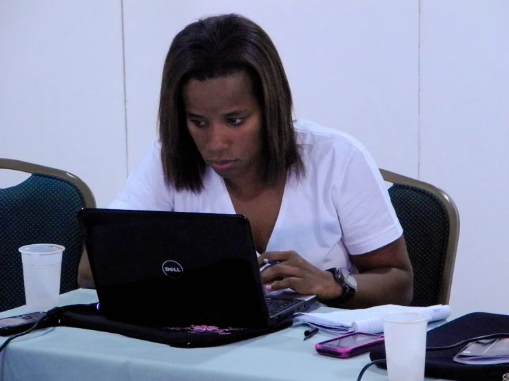 a woman is looking at her laptop screen