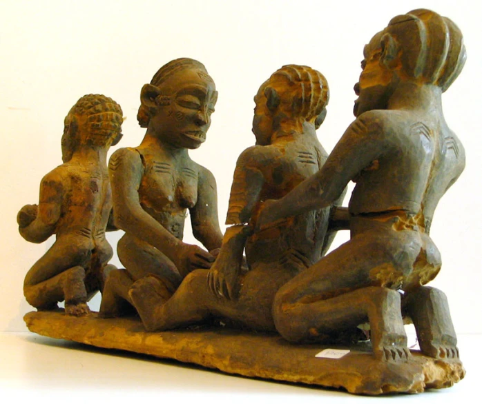 a sculpture of children sitting on a platform in different sizes