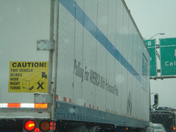 a large white truck with a yellow caution sign on it's side