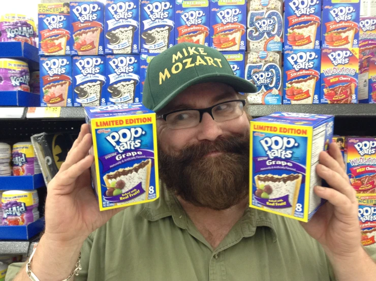 the man is wearing a hat and holding two frozen desserts