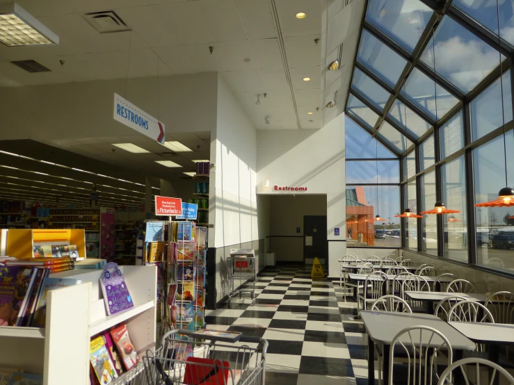 a large window in the wall next to some tables and chairs