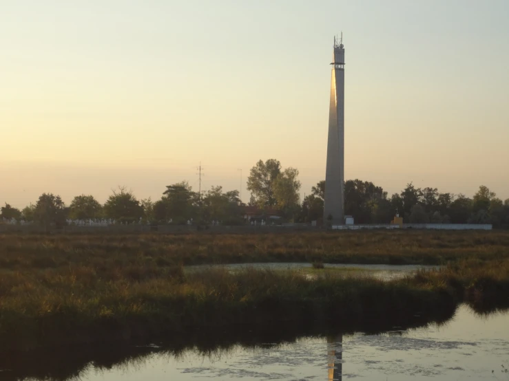 a tall monument in a vast open grassy area