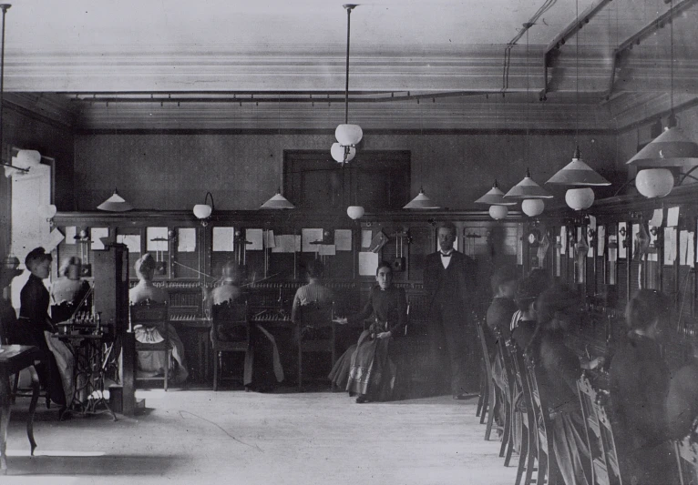 a group of people sitting at desk in an office