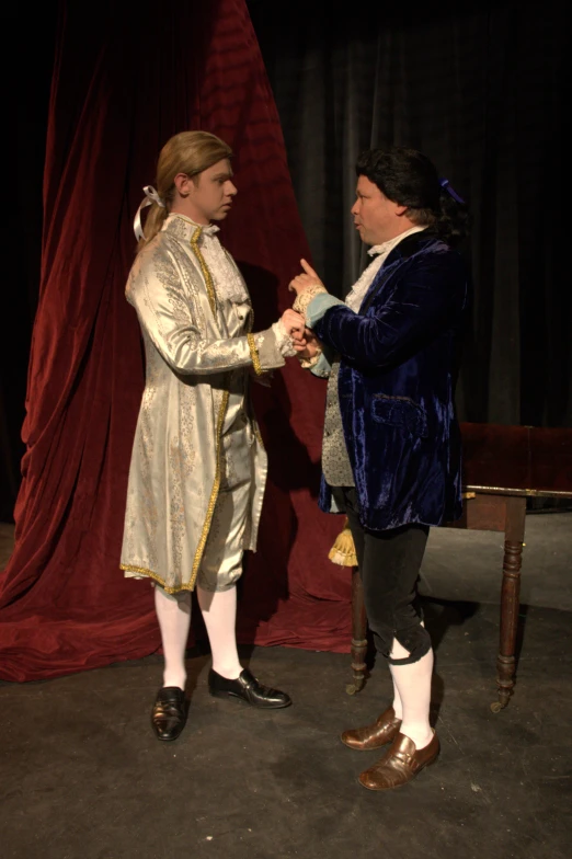 two people dressed in old - fashioned clothing greeting each other