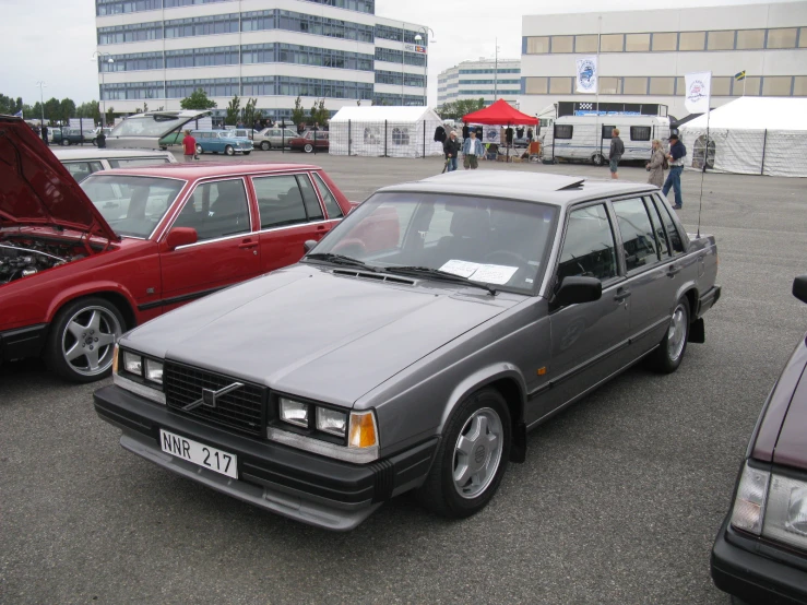 cars are lined up on the parking lot with their hood open