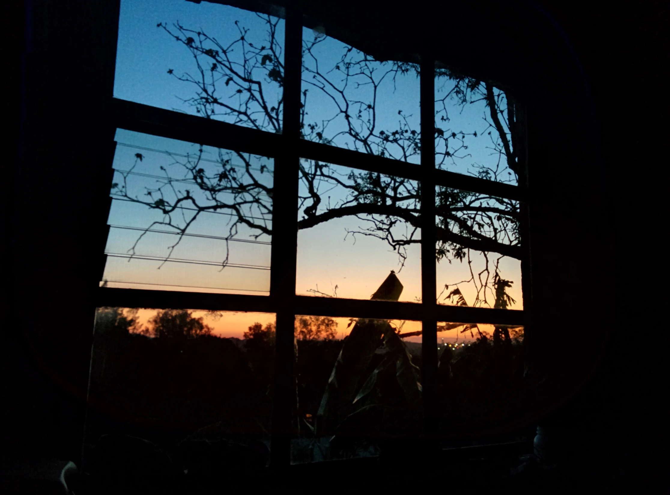 a sunset through the window shows a building in silhouette