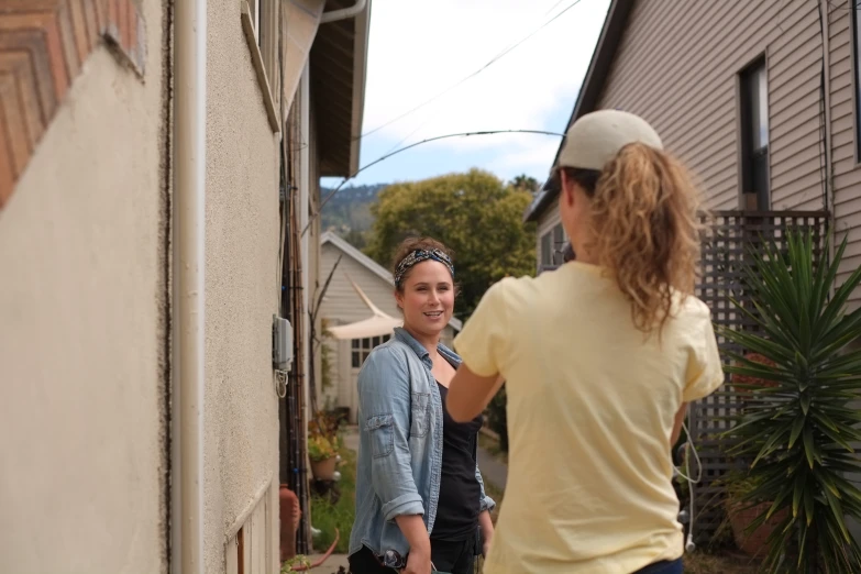 a woman in a yellow shirt taking a picture with a friend