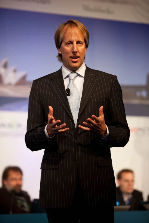 a man standing in front of a microphone giving a presentation