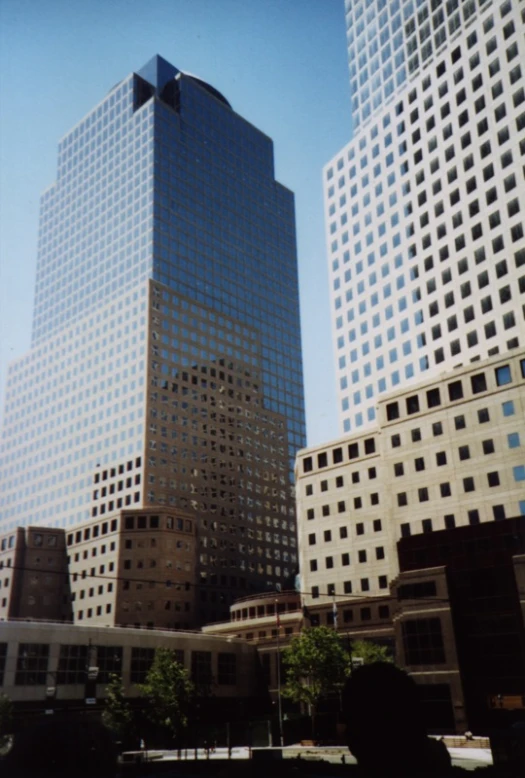 city buildings with some trees and blue sky in the background