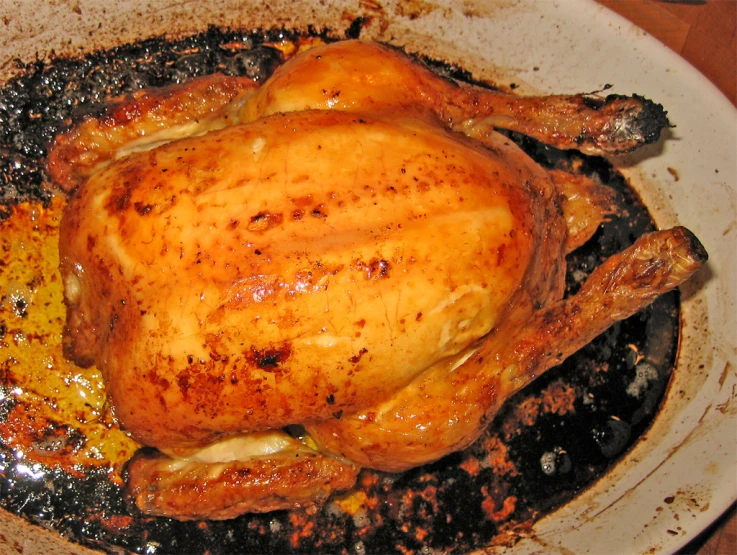 a roasted chicken sitting inside of a pan