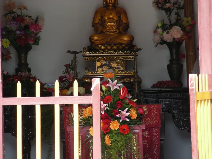 an image of a shrine with flowers on the floor