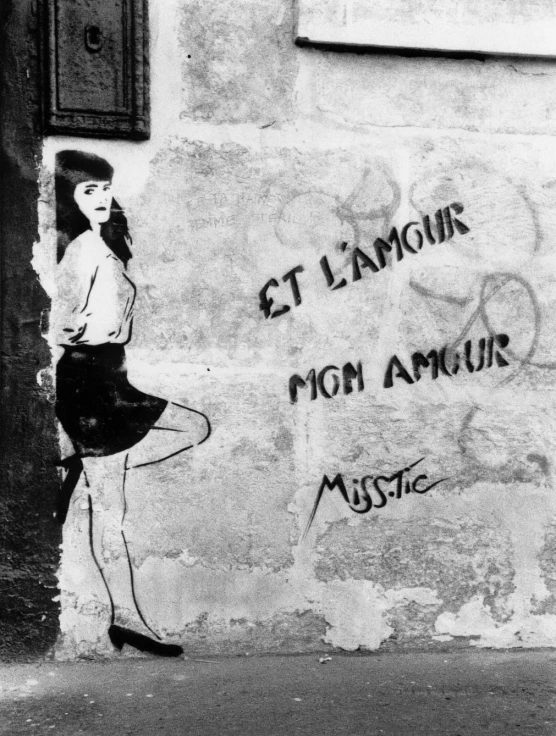 the woman is posing in front of a graffiti wall