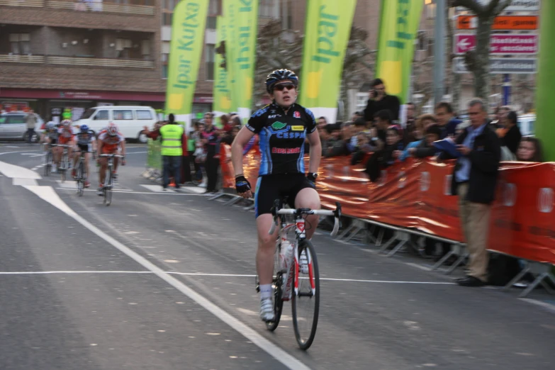 a man riding a bike down a street next to lots of people