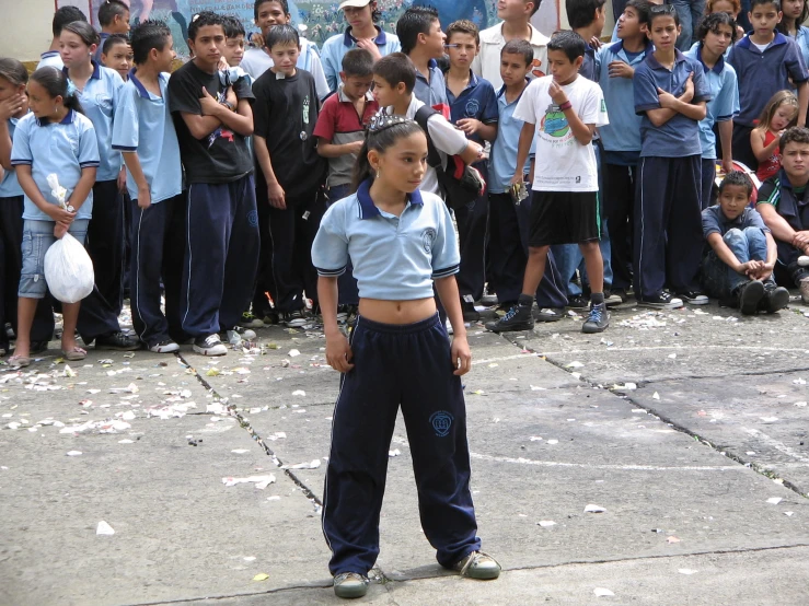 a group of s watching as a boy stands in front of a crowd of people