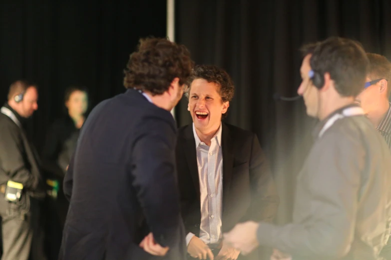 men laughing together in a room during a meeting