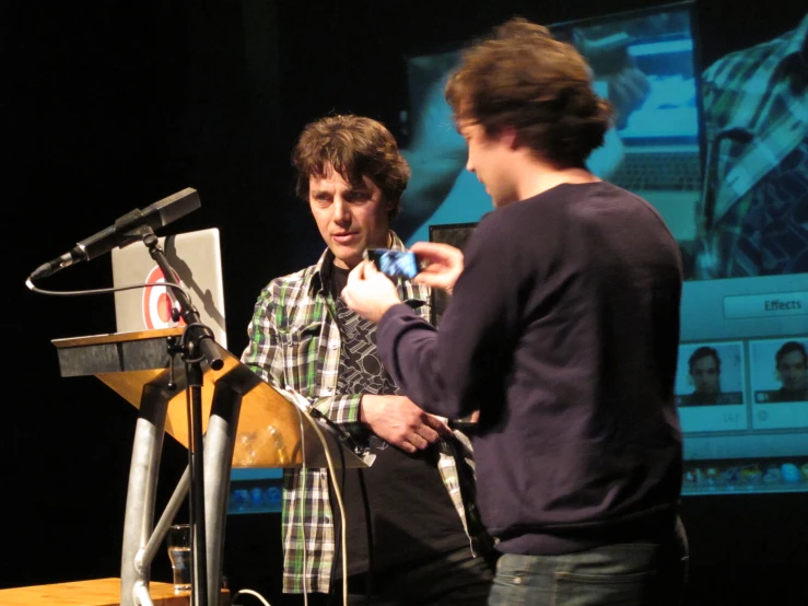 two men standing next to each other at a podium