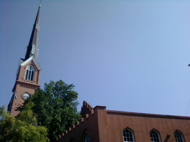 a church with a steeple surrounded by trees