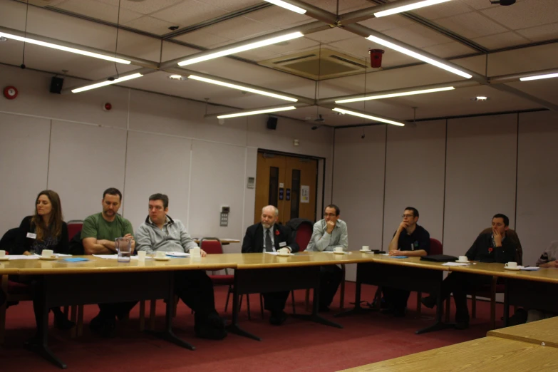 several people sit at a long conference table