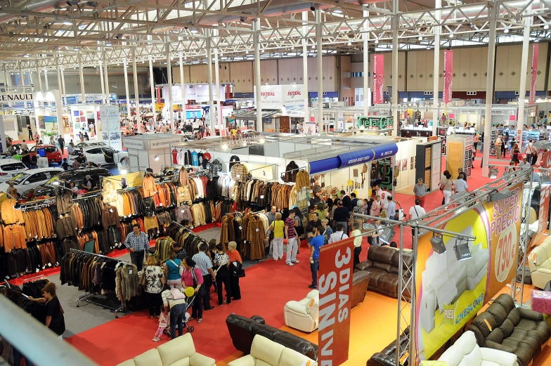 an indoor convention with several booths and people looking at them