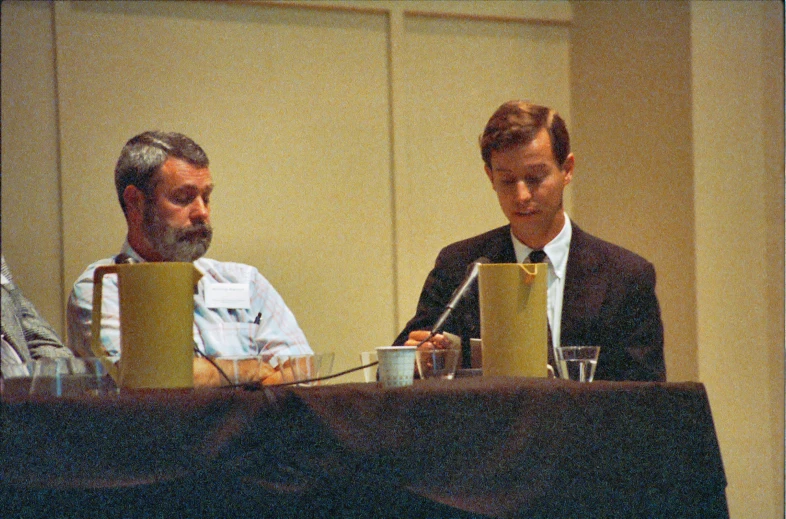 two men are sitting down at a table