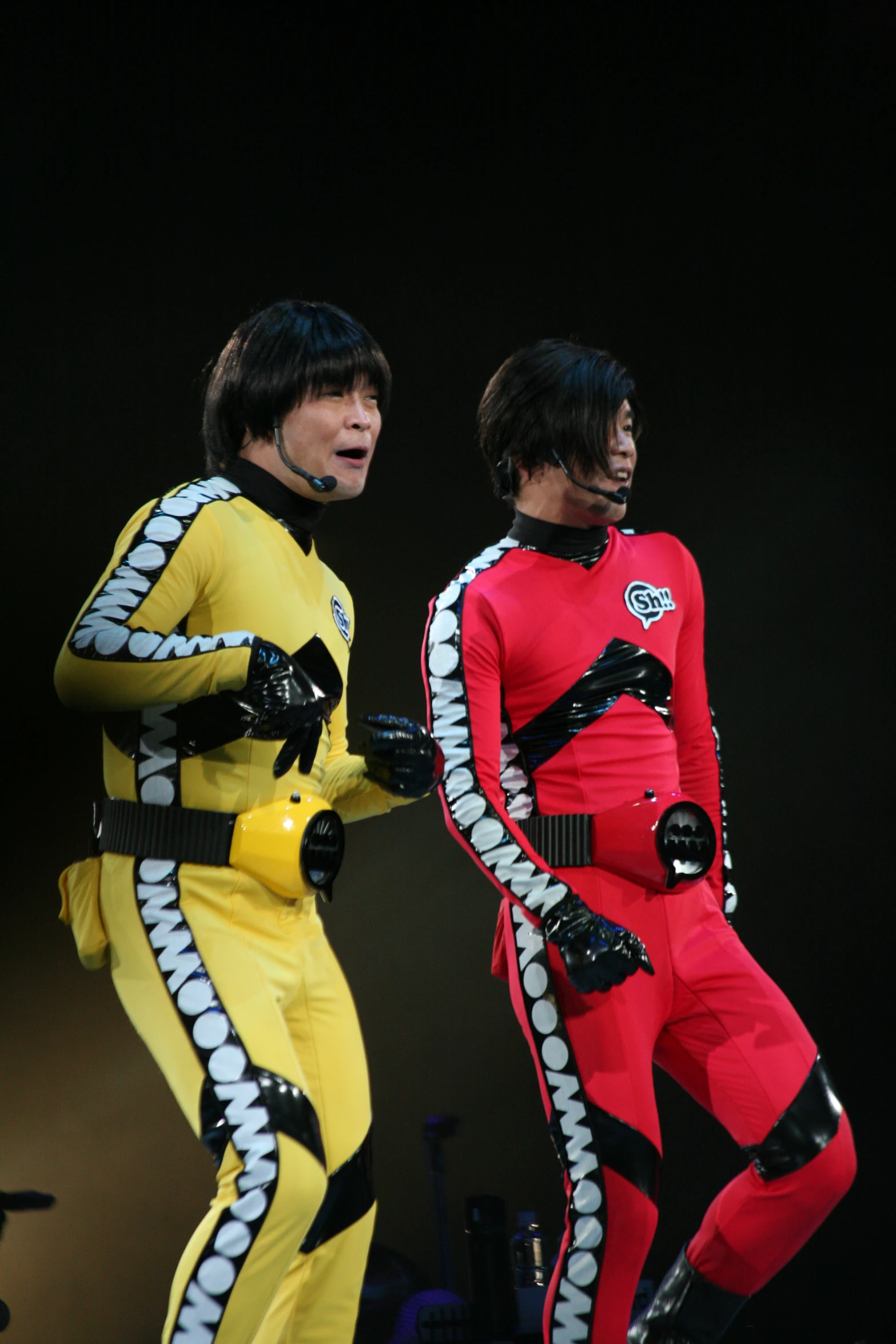 two male wearing red and yellow outfits with white stripes