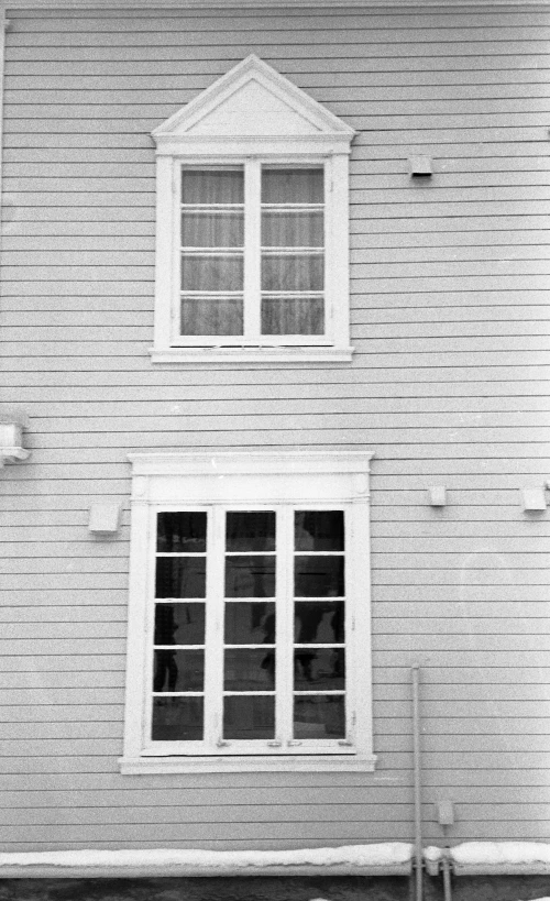 an exterior view of a white house with an outside window