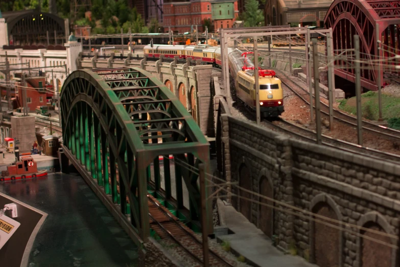 a small train going across a bridge over a river
